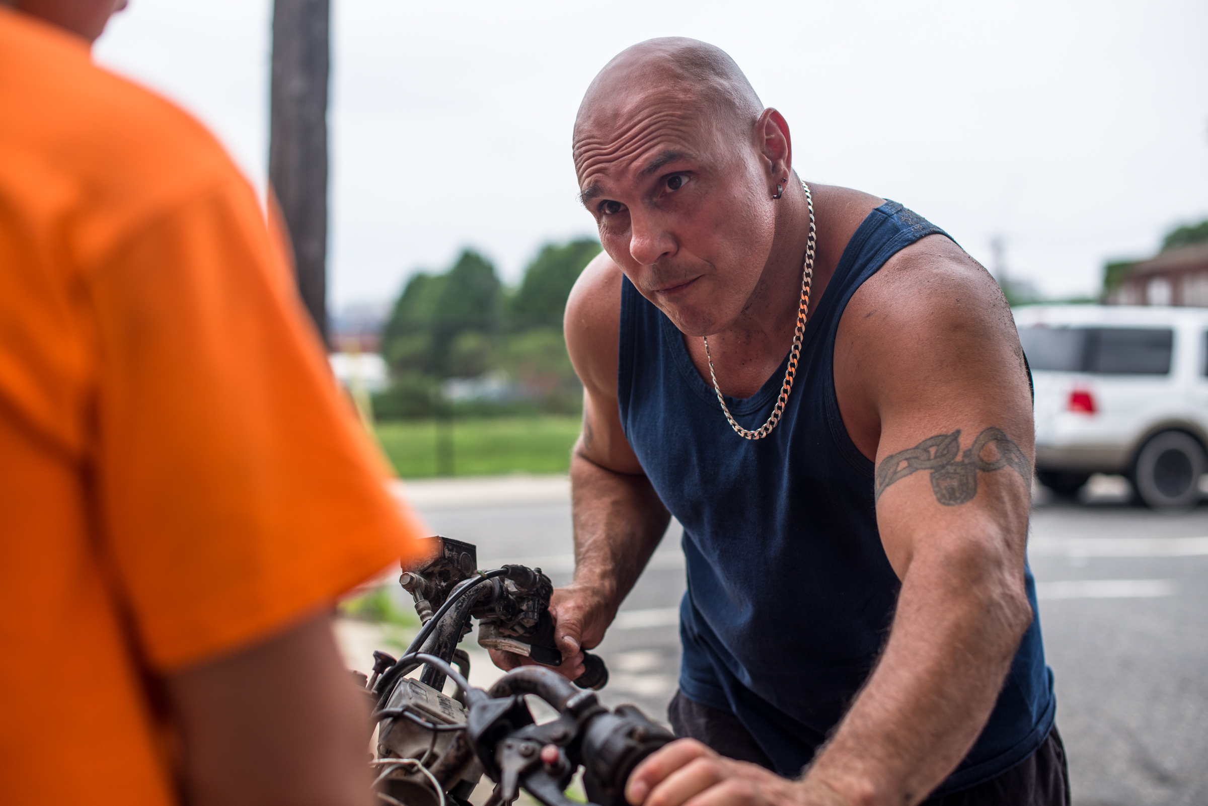 Philadelphia, PA - June 20, 2015 - Forgotten Bottom. Anthony and his son working on the brakes of their ATV/Quad, which is from 1986. They got it for free.