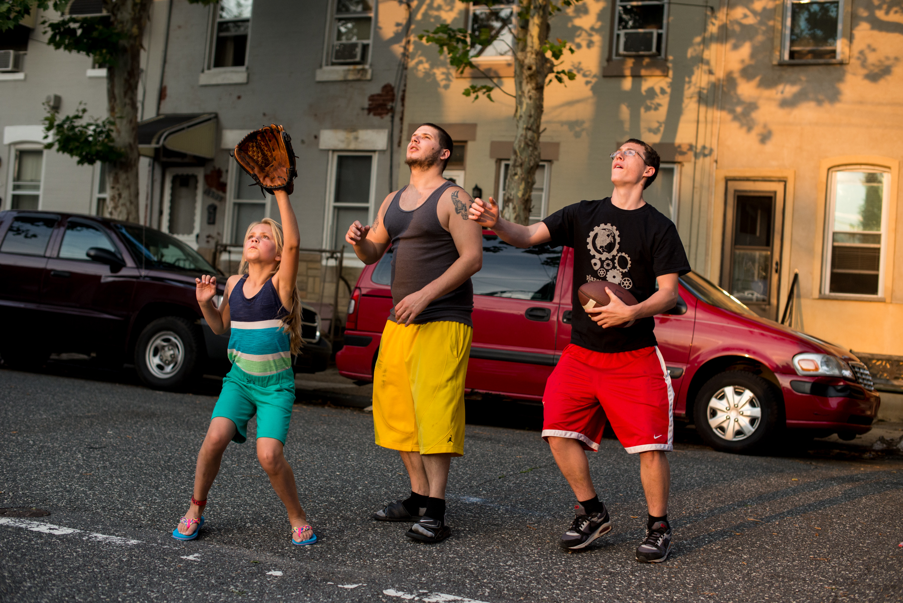 Philadelphia, PA - July 1, 2015 - Older guys playing with younger kids in the neighborhood. Forgotten Bottom.