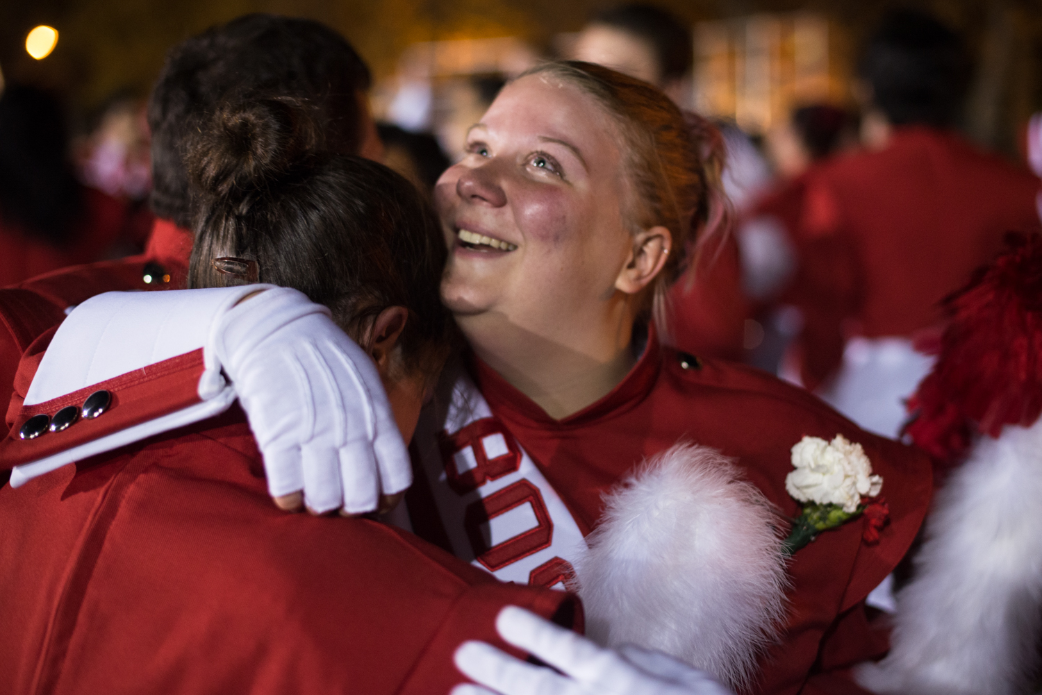 Taylor Kenyon (right) hugs a friend among fellow BU band members gathering following her last performance as a college marching band member.