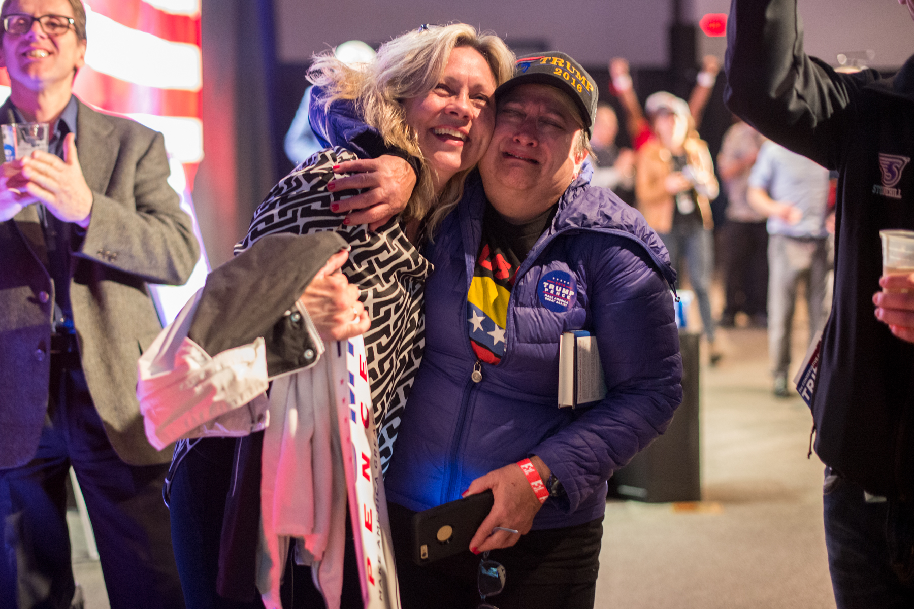 Braintree, MA – Nov. 8, 2016 – Susan Tittle, left, embraces Debbie Makowski as United States presidential election results are reported on Fox News during the Massachusetts Trump-Pence Campaign victory party. Trump supporters gathered at the F1 Boston race track to cheer on their nominee as he was elected 45th president of the United States.
